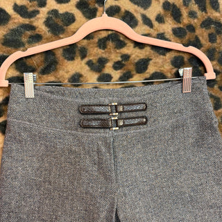 Gray herringbone pants on a pink hanger against a leopard print background