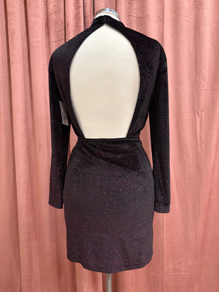 Black dress on a mannequin against a pink curtain background