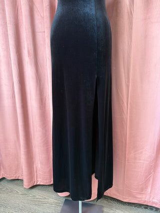 Black dress on a mannequin against a pink curtain background